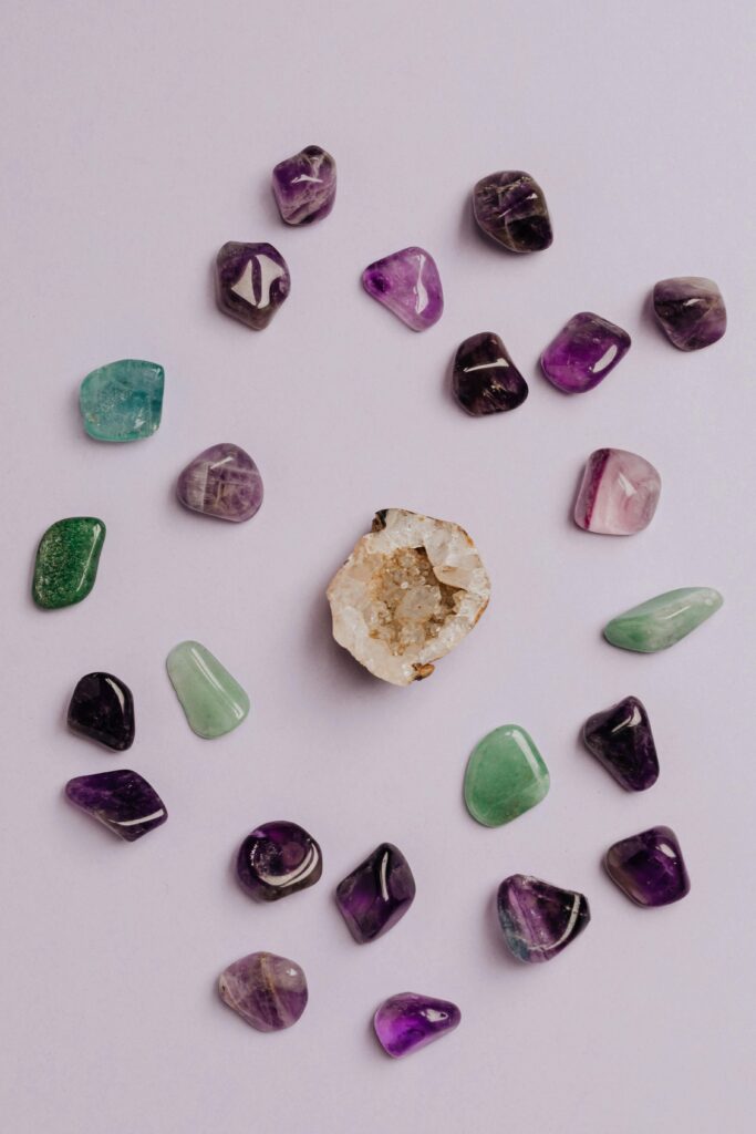 A collection of colorful tumbled gemstones artfully arranged on a neutral background.